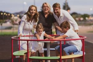 een ouderen paar in gewoontjes kleren met hun kinderen en grootmoeder besteden tijd samen in de park Aan vakantie. familie tijd. selectief focus foto