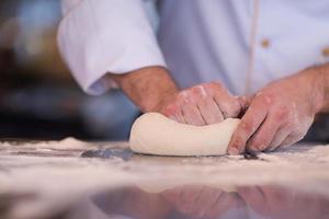 chef handen voorbereidingen treffen deeg voor pizza foto