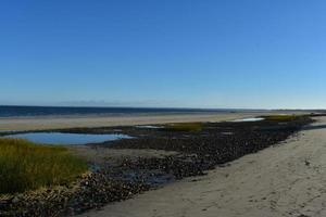 mooi strand met zwart rotsen overschrijding de strand foto