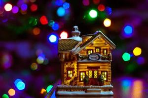 Kerstmis huis figuur Aan tafel Aan veelkleurig wazig bokeh achtergrond foto