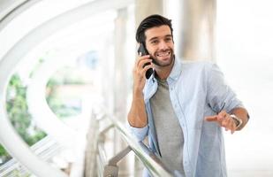 de bedrijf Mens pratend met slim telefoon Aan hun manier. gevoel gelukkig en ontspannend, gewoontjes jong zakenman vervelend pak jasje. foto