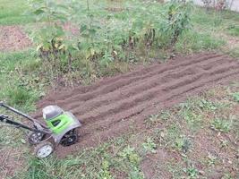 kyiv oblast, Oekraïne - oktober 02, 2022 teelt van bedden met een handleiding elektrisch cultivator foto