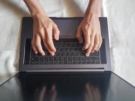 mannetje handen typen Aan laptop toetsenbord foto