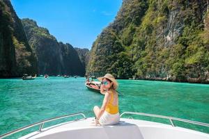 vrouw toerist op boottocht, gelukkige reiziger ontspannen bij pileh lagune op phi phi island, krabi, thailand. exotisch oriëntatiepunt, bestemming Zuidoost-Azië reizen, vakantie en vakantieconcept foto