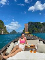 vrouw toerist in privé longtail boottocht naar eiland met exotisch eten picknick, krabi, thailand. oriëntatiepunt, bestemming, reizen naar Azië, vakantie, reislust en vakantieconcept foto