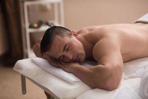 knap Mens resting in een spa massage centrum foto