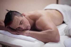 knap Mens resting in een spa massage centrum foto