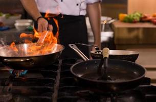 chef aan het doen flambe Aan voedsel foto