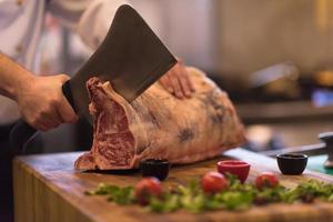 chef snijdend groot stuk van rundvlees foto