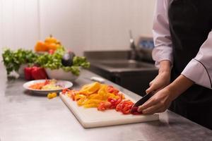 chef snijdend vers en heerlijk groenten foto