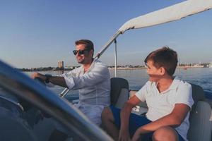 vader en zoon genieten hun vakantie samen terwijl rijden een luxe boot Bij zee. selectief focus foto