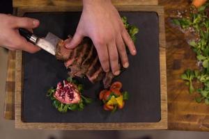 top visie van chef handen voorbereidingen treffen rundvlees steak foto