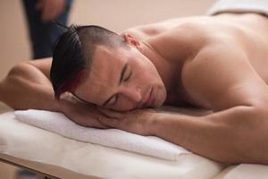 knap Mens resting in een spa massage centrum foto