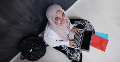 Arabisch vrouw leerling werken Aan laptop van huis foto