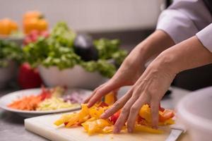 chef snijdend vers en heerlijk groenten foto