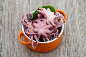 gemarineerde octopus in een kom op houten achtergrond foto