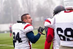 zelfverzekerd Amerikaans Amerikaans voetbal spelers weggaan de veld- foto