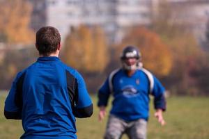 Amerikaans Amerikaans voetbal team met trainer in actie foto