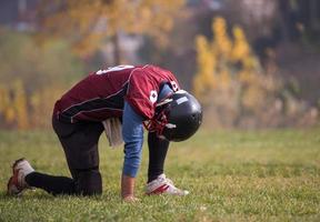 Amerikaans Amerikaans voetbal speler resting na moeilijk opleiding foto