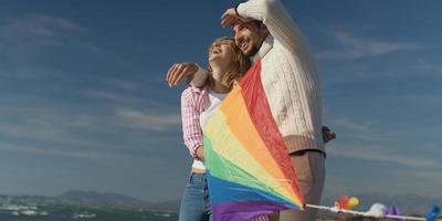 gelukkig paar hebben pret met vlieger Aan strand foto