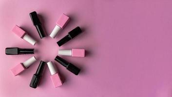 reeks van flesjes met kleurrijk nagel lak geplaatst in cirkel Aan roze achtergrond foto