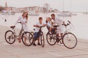 de gelukkig familie geniet een mooi ochtend- door de zee rijden een fiets samen en uitgeven tijd samen. de concept van een gelukkig familie foto