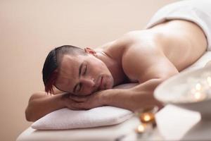 knap Mens resting in een spa massage centrum foto