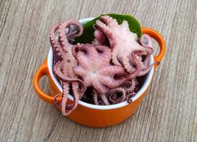 gemarineerde octopus in een kom op houten achtergrond foto