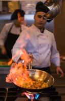 chef aan het doen flambe Aan voedsel foto