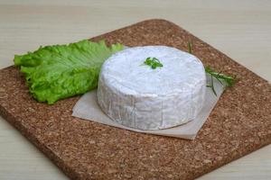 Camembert kaas Aan houten bord en houten achtergrond foto