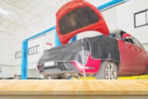 leeg hout tafel top met auto onderhoud centrum auto reparatie werkplaats wazig achtergrond foto