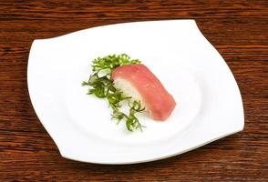 tonijn sushi Aan de bord en houten achtergrond foto