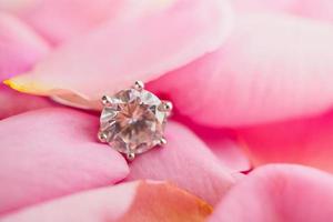 sieraden diamanten ring op mooie roze rozenblaadje achtergrond foto