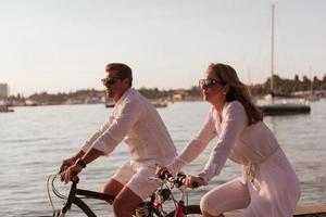 senior paar genieten van een mooi ochtend- samen rijden een fiets door de zee. selectief focus foto