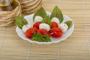 Caprese salade op de plaat en houten achtergrond foto