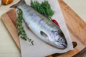 rauw forel Aan houten bord en houten achtergrond foto