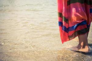 detailopname van een vrouw staand in Ondiep water Bij de strand. foto