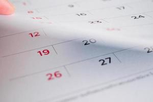 hand- houden kalender bladzijde flippen vel dichtbij omhoog achtergrond foto