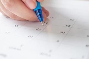 vrouw hand- met pen schrijven Aan kalender datum bedrijf planning afspraak vergadering concept foto