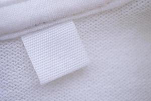 blanco wit kleren etiket Aan nieuw overhemd achtergrond foto
