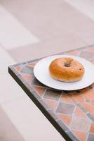 ontbijt ochtend- zonnig warm weer met donut Aan wit bord Aan tafel achtergrond. mooi zo humeur horizontaal visie foto