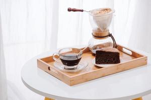 druppelen koffie druppelaar en druppelen grond koffie met glas druppelen pot, kop en chocola taart foto