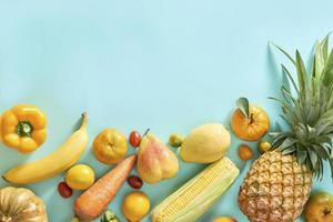 verzameling van vers geel fruit en groenten Aan de licht blauw achtergrond foto