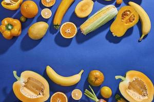 verzameling van vers geel fruit en groenten Aan de blauw achtergrond foto