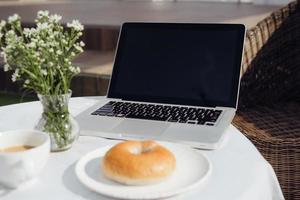 laptop, brood en cafe in koffie winkel foto