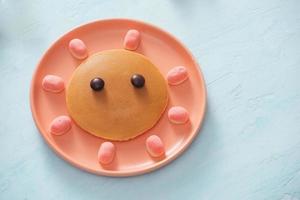 smakelijk gebakken pannenkoek met mooi gezicht geïsoleerd, zoet toetje foto