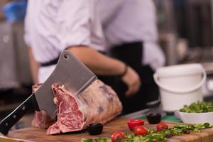 chef snijdend groot stuk van rundvlees foto