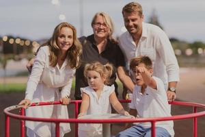 een ouderen paar in gewoontjes kleren met hun kinderen en grootmoeder besteden tijd samen in de park Aan vakantie. familie tijd. selectief focus foto