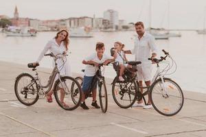 de gelukkig familie geniet een mooi ochtend- door de zee rijden een fiets samen en uitgeven tijd samen. de concept van een gelukkig familie foto