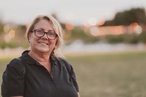 portret van een ouderen vrouw met blond haar- en bril Aan de stranden van de middellandse Zee zee Bij zonsondergang. selectief focus foto